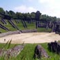  Témoignage de l'époque romaine, l'amphithéâtre est achevé au début du règne de l'empereur Claude. Mesurant 126 mètres sur 102, il est reconnaissable à sa structure particulière, la cavea étant appuyée sur deux versants du « Vallon des Arènes » et sur un remblai. Animaux sauvages et gladiateurs accédaient à l'arène par deux vomitoria établis à l'ouest et à l'est.