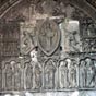 Cahors : Le tympan de la cathédrale - Sculpté en 1135 sur la façade nord, ce portail à voussures est surmonté d'un remarquable tympan dont les sculptures, rappelant celles de Moissac, sont d'un style transitoire entre le roman et le gothique. Le thème en est la Parousie du Christ. Jésus, debout, la main droite levée en signe de bénédiction, une bible dans la main gauche, est entouré d'une gloire ovale (ou mandorle) qui souligne le mouvement ascensionnel. De chaque côté du Christ, deux anges semblent expliquer le miracle aux apôtres, qui, sous leurs arcatures trilobées, entourent la Vierge. À gauche, un personnage isolé dont l'attitude et le vêtement différent de ceux des apôtres, représente probablement le sculpteur qui signe ainsi son œuvre. De part et d'autre des anges, est racontée l'histoire de saint Étienne, patron de la cathédrale, telle qu'elle figure dans les Actes des Apôtres. Au-dessus de la mandorle, quatre angelots accompagnent le Christ dans son ascension. L’archivolte est ornée de personnages très maigres, très longs et se faisant face. Ils illustrent des scènes de chasse, le combat des vices et des vertus. À remarquer aussi, les voussures sculptées et les corbeaux de la corniche.