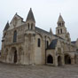 Poitiers : Eglise Notre Dame La Grande. L'église est mentionnée dès le Xe siècle sous le vocable de Sancta Maria Major référence à l'église romaine du même vocable, Sainte-Marie-Majeure. Possédant un double statut, collégiale et paroissiale, elle fait partie du domaine de l'évêque de Poitiers. Sa position jouxte le Palais des Comtes de Poitou-Ducs d'Aquitaine (actuel palais de justice de Poitiers), n'est certainement pas innocente du point de vue politique, les évêques de Poitiers étant barons du Poitou. L'ensemble de l'édifice est reconstruit dans la seconde moitié du XIe siècle, en pleine période romane, et consacré en 1086 par le futur pape Urbain II.  Le clocher date du XIe siècle. Il était à l'origine beaucoup plus marqué : le premier niveau est aujourd'hui dissimulé par les toitures. Situé à l'emplacement de la croisée, il présente une base carrée puis un niveau circulaire surmonté d'un toit en écailles. (Photo Dominique Trioire)