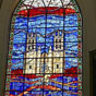 Intérieur de l'église Saint-Roch : Ce vitrail contemporain (maître-autel) installé vers 1980 représente saint Roch cheminant avec son chien vers la cathédrale de Montpellier.